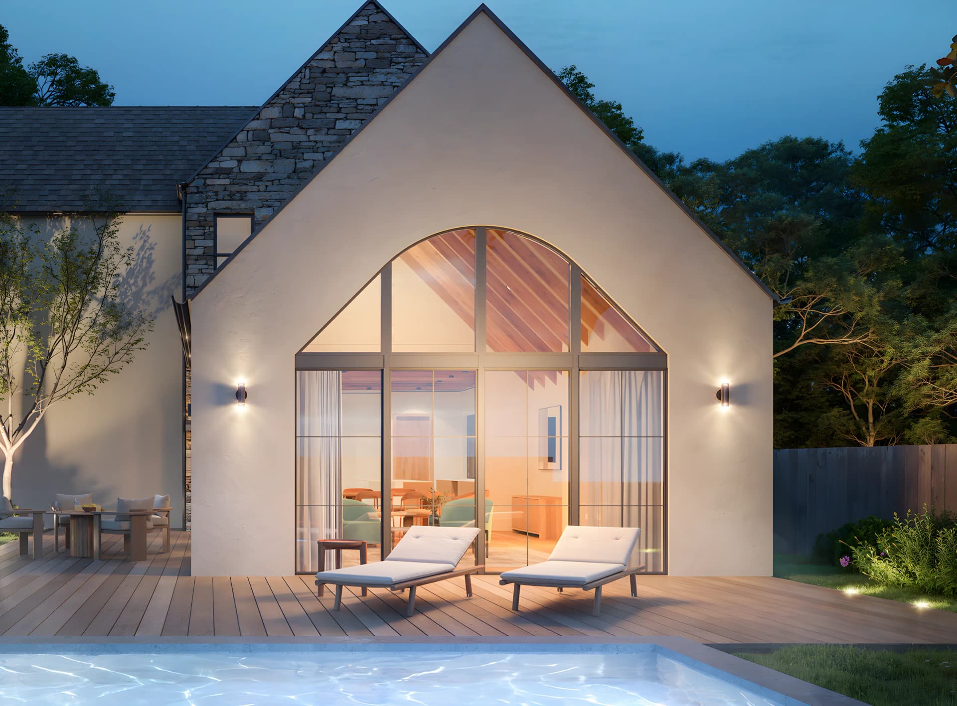 Emerald Forest at dusk: a gabled stone and stucco home above a lit pool terrace.